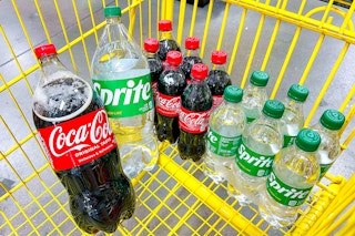 coke and sprite sodas in a yellow shopping cart