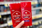 hand holding two sticks of Old Spice Classic deodorant