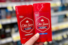 hand holding two sticks of Old Spice Classic deodorant