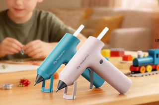 two hot glue guns on craft table