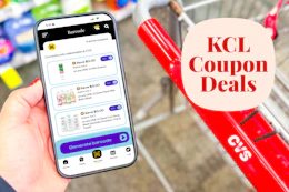 hand holding a smartphone displaying KCL Coupons next to a cvs shopping cart