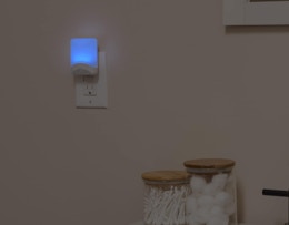 a blue night light plugged into a wall 