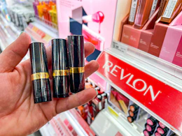 hand holding revlon lipstick in front of target shelf