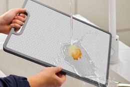 a man washing a stainless steel cutting board