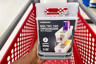 hand holding a madesmart mini two-tier organizer with dividers over a target cart
