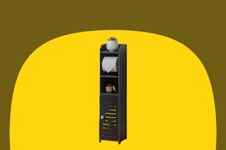 Black bathroom storage cabinet with a place to hang toilet paper and a slim door on the bottom half