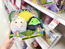 hand holding a squishmallows wicked plush set in front of a target shelf