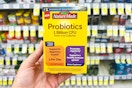 person holding nature made probiotics in front of the shelf