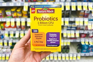 person holding nature made probiotics in front of the shelf