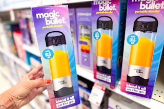 hand holding a magic bullet blender in front of a target shelf