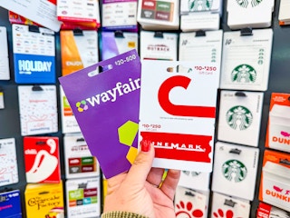hand holding wayfair and cinemark gift cards