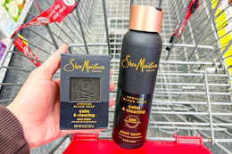 person holding a sheamoisture bar soap next to a body wash in a cart