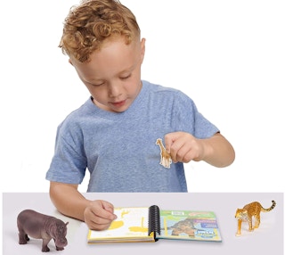 a kid playing with a journal and animal figures