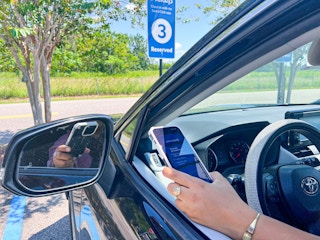 Person in their car holding a phone.
