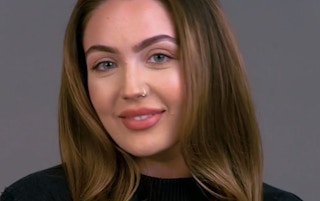 A woman smiling with NYX makeup on.