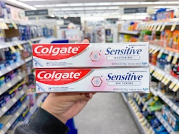 hand holding colgate toothpastes in walgreens