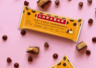 Larabars on a pink surface next to chocolate chips
