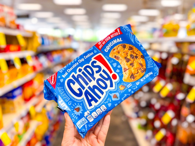 person holding a package of chips ahoy cookies in an aisle