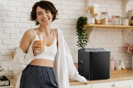 lifestyle image of a person standing by a countertop ice maker