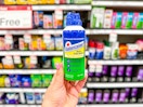 hand holding solarcaine first aid spray in front of target shelves