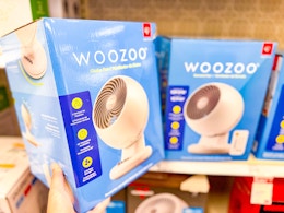 hand holding a woozoo fan in front of a target shelf