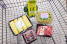 corn, avocadoes, wagyu beef, ribeye steak, and cotton candy grapes in a cart