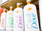 four bottles of Dove serum body wash on shelf