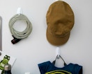 hooks on a wall with hats and tote bags 
