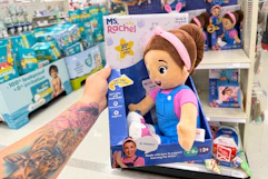 hand holding a ms rachel speak & sing doll in front a target shelf