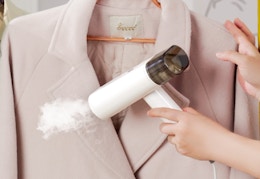 a person using a clothing steamer on a pink blazer