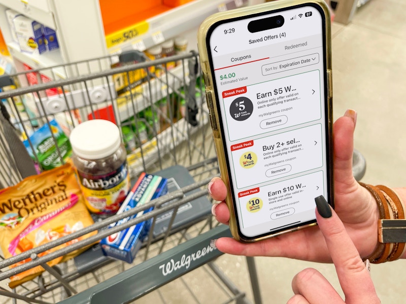 someone holding phone with walgreens app next to cart