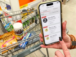 someone holding phone with walgreens app next to cart