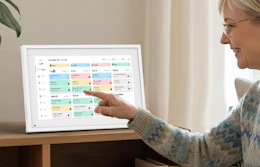 a person touching a digital calendar on  a table 