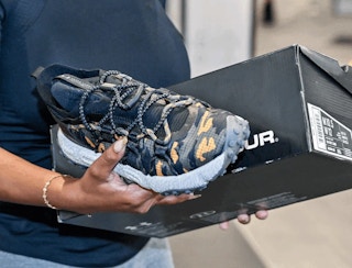 Someone looking at some shoes in an Under Armour store
