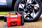 Lifestyle image of the Craftsman air inflator being use to fill up a car tire