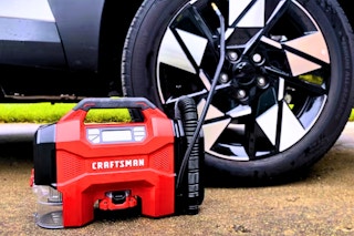 Lifestyle image of the Craftsman air inflator being use to fill up a car tire