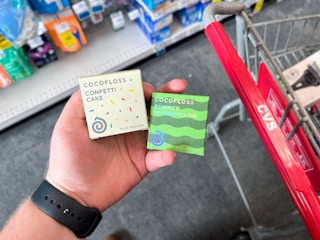 hand holding two boxes of Cocofloss flavored floss