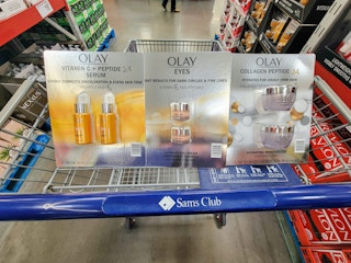 a sam's club cart with olay facial serum, eye cream, and moisturizer