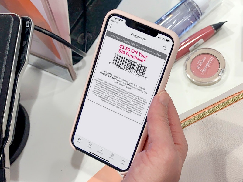 person with an ultamate rewards coupon on iphone checking out at ulta