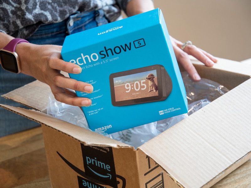 A person taking an Amazon Echo Show 5 out of an Amazon delivery box.