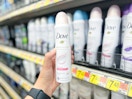 a person holding a can of deodorant spray in a store aisle 