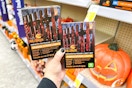 person holding 2 boxes of halloween string lights