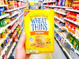 hand holding a box of wheat thins crackers
