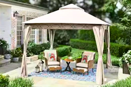 Lifestyle image of a tan soft top gazebo in an outdoor setting