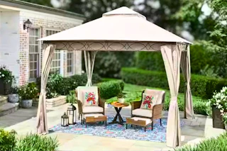 Lifestyle image of a tan soft top gazebo in an outdoor setting