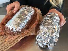 two chipotle burritos on table