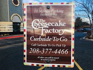 A 10 minute parking sign to designate the Curbside-to-go parking space outside of The Cheesecake Factory.