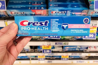 hand holding a box of crest toothpaste at kroger