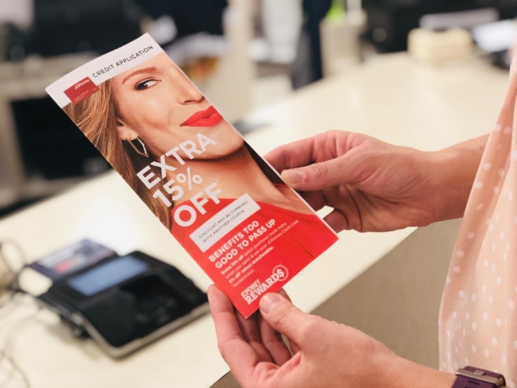 Hand holding a JCPenney Credit Card Pamphlet in store