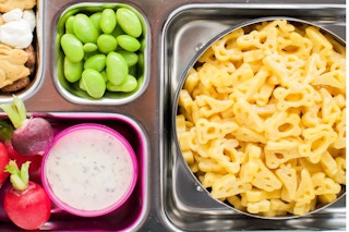 mac and cheese with fruits and snacks in individual slots on a tray